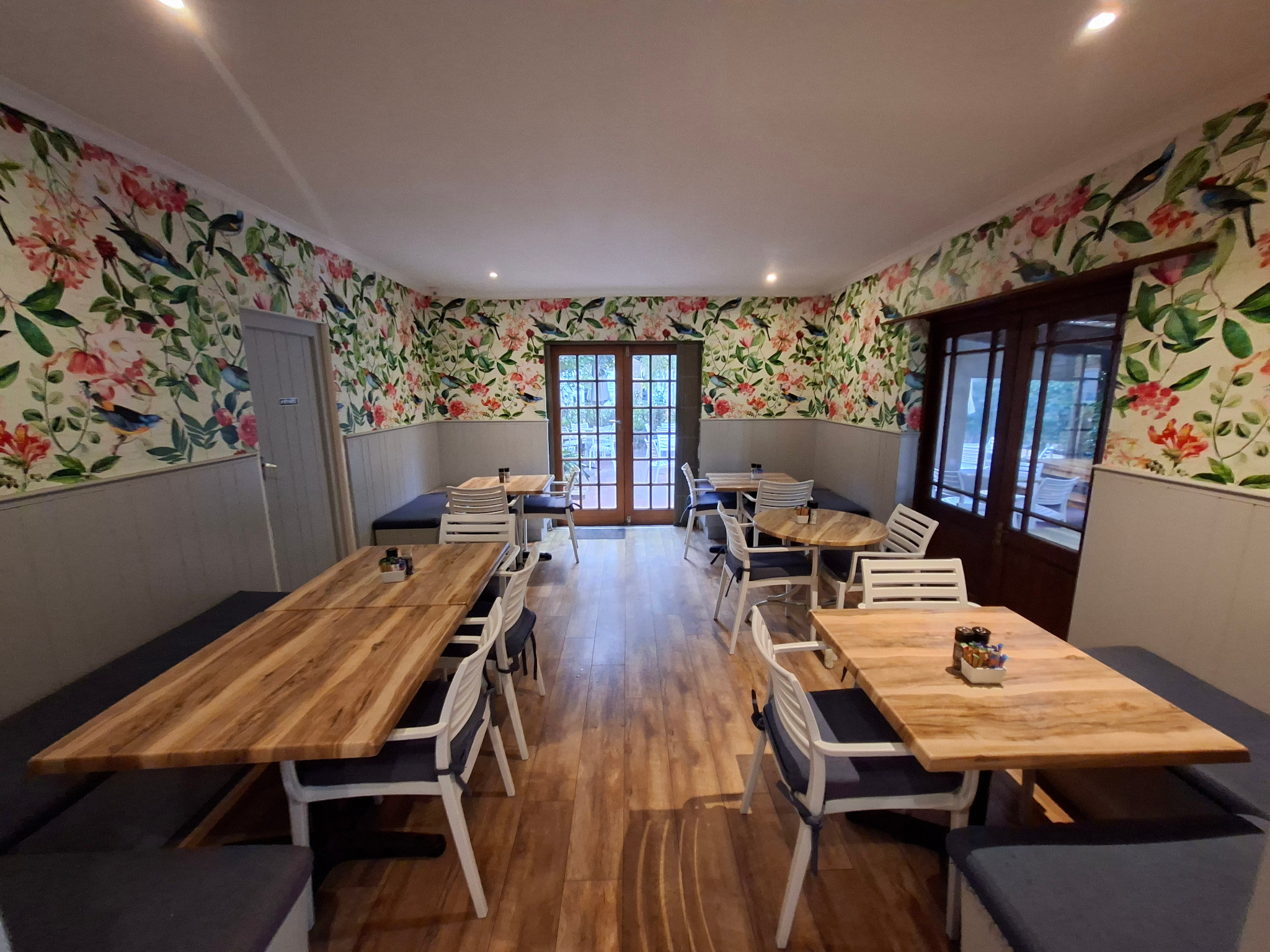 Fraîche Ayres Rose Room with botanical wallpaper and wooden tables